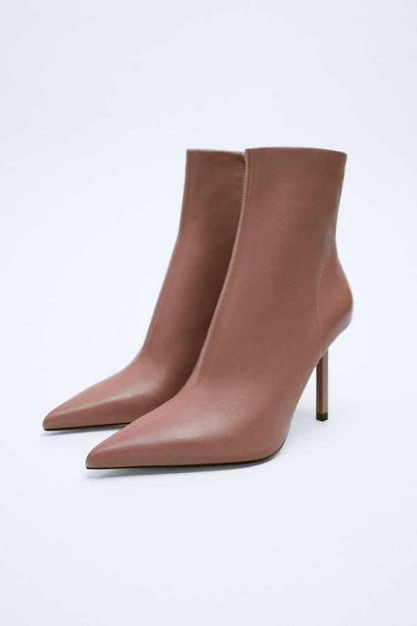 Unos botines de tacón en un color inesperado pero muy combinable. Perfectos para un look de oficina elegante y sofisticado pero también para salir de noche. Botines de piel color rosa de Zara (79,99 euros). 