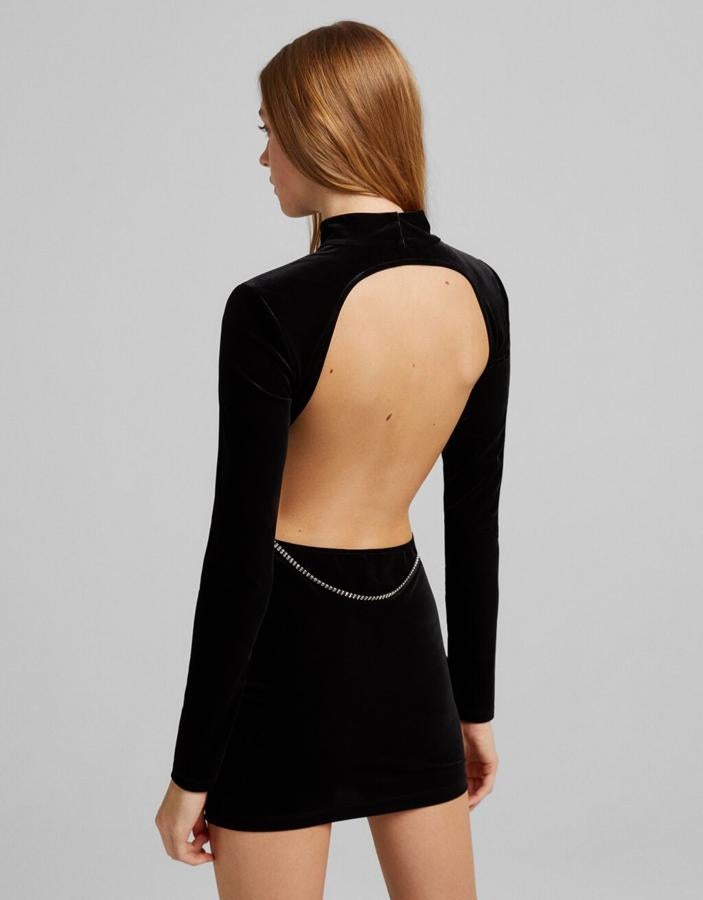 Con espalda al aire y detalle de tira de strass en la parte posterior de la cintura, este vestido negro de terciopelo de Bershka con cuello alto y mangas largas tiene un precio de 29,99 euros y solo queda en las tallas L y XL. 