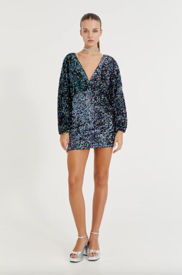 Con lentejuelas en tonos azulados y lilas, escote amplio de pico y mangas largas, este vestido mini de terciopelo de Pull&Bear está disponible entre las tallas XS y L por 35,99 euros. 