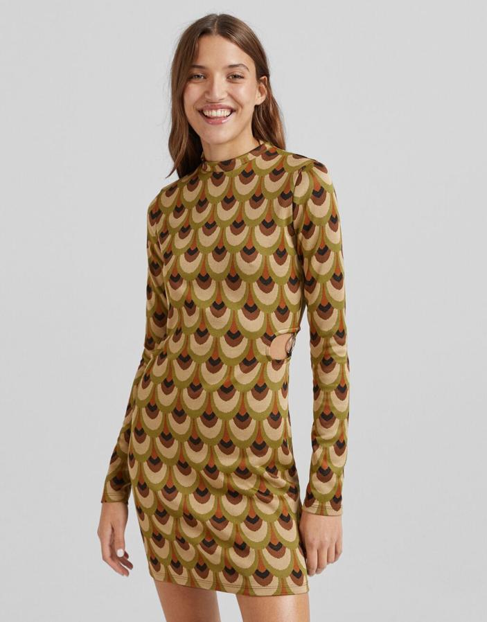 En tonos verdes y marrones y estampado de escamas, este vestido de Bershka con aberturas cut out en la cintura con arandelas y cuello redondo en jacquard cuesta 22,99 euros y está disponible entre las tallas XS y L. 