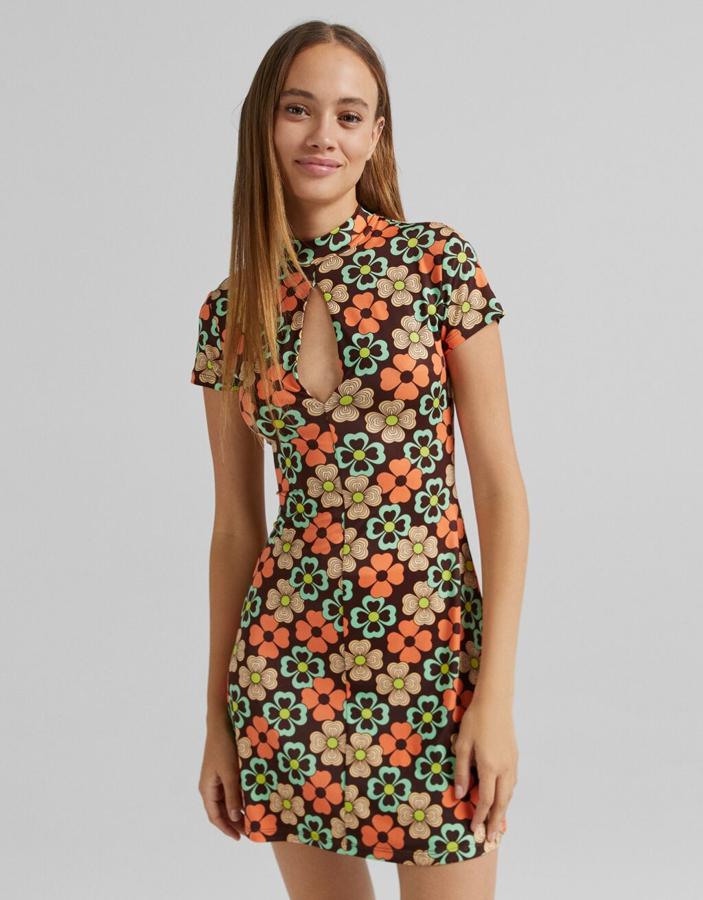 Mangas cortas y abertura en el escote para este vestido de Bershka en color marrón con estampado de flores en salmón y aguamarina que cuesta 19,99 euros y solo queda en las tallas XS, S y M.