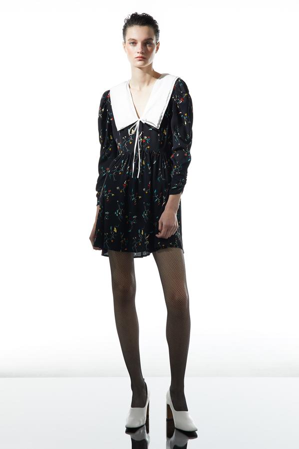 Cuello babydoll a contraste en blanco para este vestido negro mini de Sfera con estampado minimalista de flores en varios colores que viene con cuello amplio y cierre de lazada. Tiene un precio de 35,99 euros y está disponible en las tallas S, M y L. 