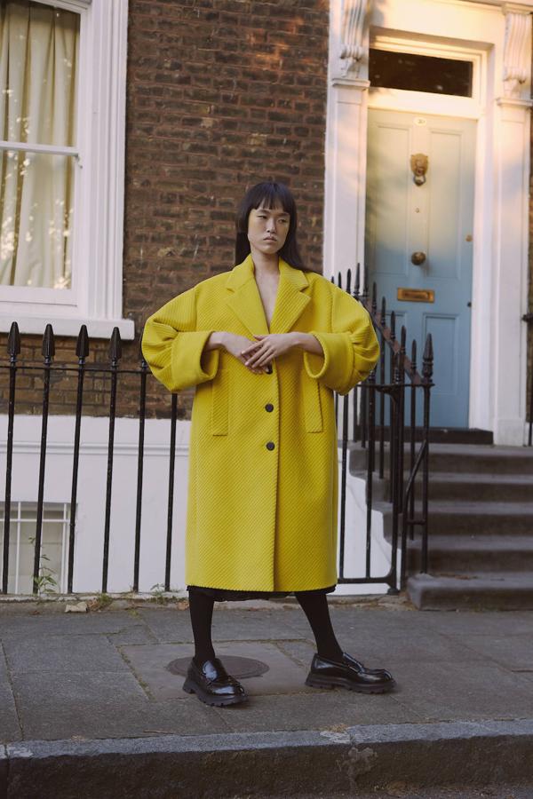 Abrigo con manga farol y vestido, ambos de Prada; medias de Givenchy y mocasines de Alexander McQueen.