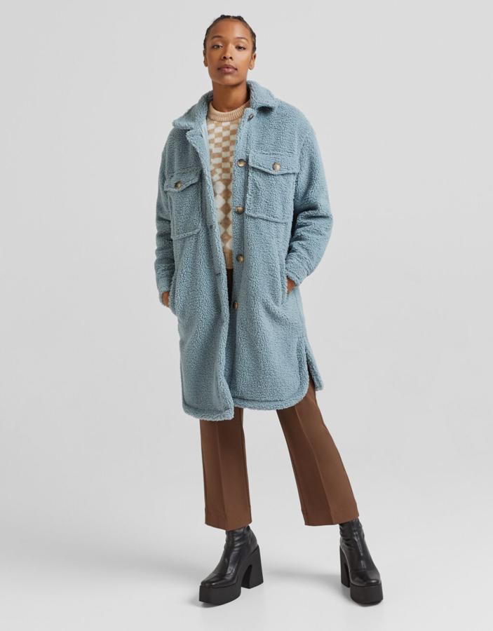 Disponible en camel o en azul claro, esta sobrecamisa larga de Bershka en efecto borrego viene con bolsillos de plastrón con solapa y botón en la pechera, bajos ligeramente redondeados y cierre de botones frontal. Están rebajadas y de 45,99 euros ha pasado a costar 32,29 euros. 