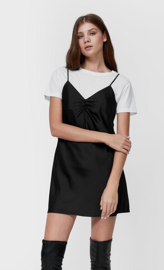 Tejido satinado y diseño mini para este vestido negro de Stradivarius con escote de pico con frunce y tirantes finos que cuesta 17,99 euros y está disponible entre las tallas XS y XL.