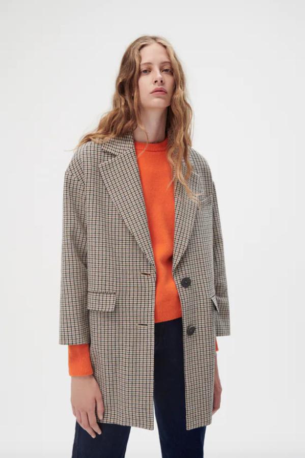 Diseño corto para este abrigo con estampado de cuadros en marrón y negro sobre fondo beige que tiene cuello de solapa, mangas largas y bolsillos delanteros con solapa. Con cierre frontal de botones a contraste, costaba 59,95 euros y en el Black Friday está por 35,97 euros. 