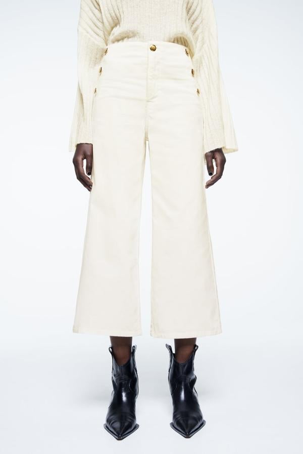 Los pantalones de pana son una de las tendencias que ha resurgido con fuerza. Este diseño en color blanco roto con botones dorados es la propuesta perfecta. Pantalones de pana de Zara (25,99 euros).