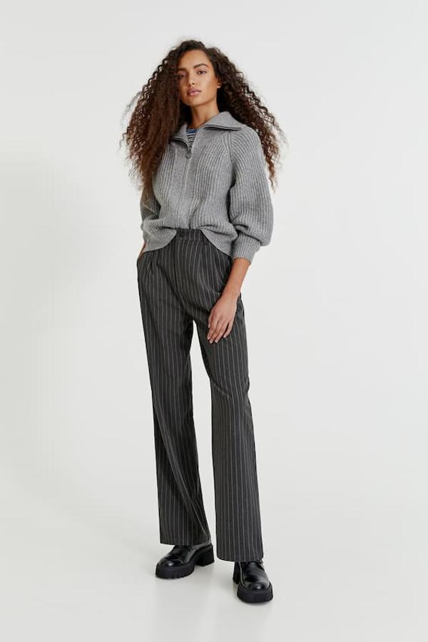 Con acabado en rib, de cuello alto y con cierre de cremallera frontal, este precioso cárdigan en color gris que podemos combinar con todo es de Pull&Bear y cuesra 29,99 euros. Está disponible entre las tallas XS y L.