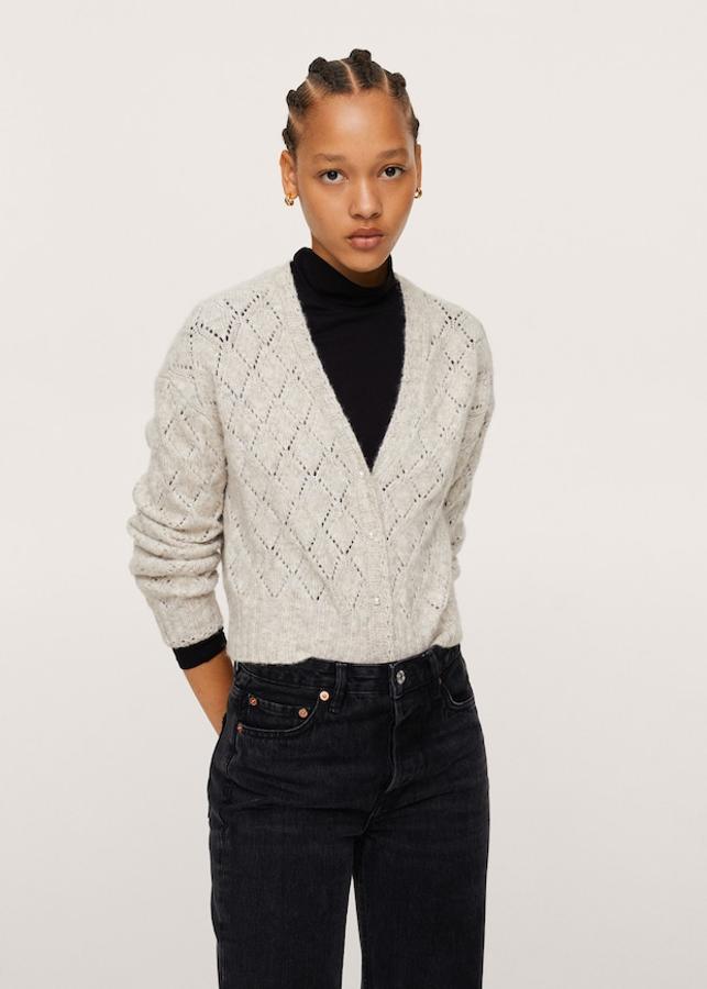 En gris claro o en verde, este cárdigan confeccionado en punto calado, de diseño crop recto y con escote de pico, viene con terminaciones de canalé y cierre frontal de botones perla y cuesta 25,99 euros. Está disponible entre las tallas XXS y XXL. 