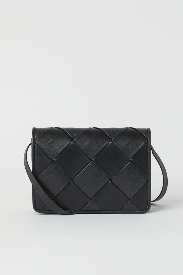 Diseño trenzado en la solapa para esta bandolera negra de H&M con correa fina ajustable y cierre magnético oculto. Podemos comprarla por 14,99 euros. 