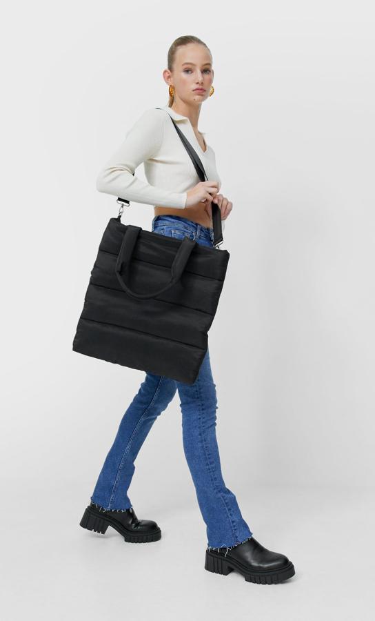 En formato shopper y un original diseño acolchado, este bolso de Stradivarius en color negro, con asa de mano y de hombro tiene un precio de 19,99 euros. 