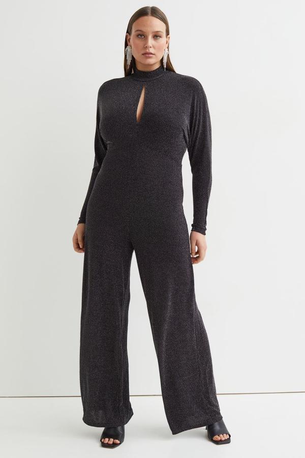 Con hilos brillantes en la trama, este mono de punto de H&M en negro viene con cuello elevado, escote de lágrima, mangas largas y perneras amplias con cintura entallada. Cuesta 29,99 euros. 