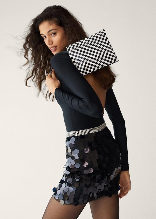 En formato mini, este bonito bolso de Mango con estampado damero en brillos viene con dos asas cortas y cierre superior de botón. Tiene un precio de 39,99 euros.