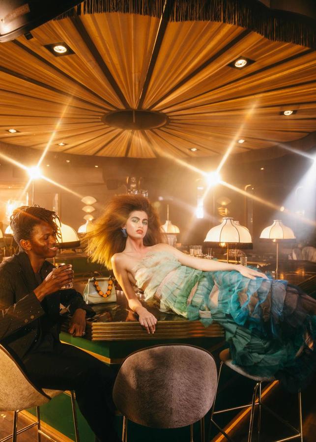 Él lleva blazer y pantalón, de Dsquared2, camisa de Emporio Armani y zapatos de Church’s. Ella, total look de Dior, bolso de Jo & Mr. Joe en El Corte Inglés y pendiente de Bimba y Lola.