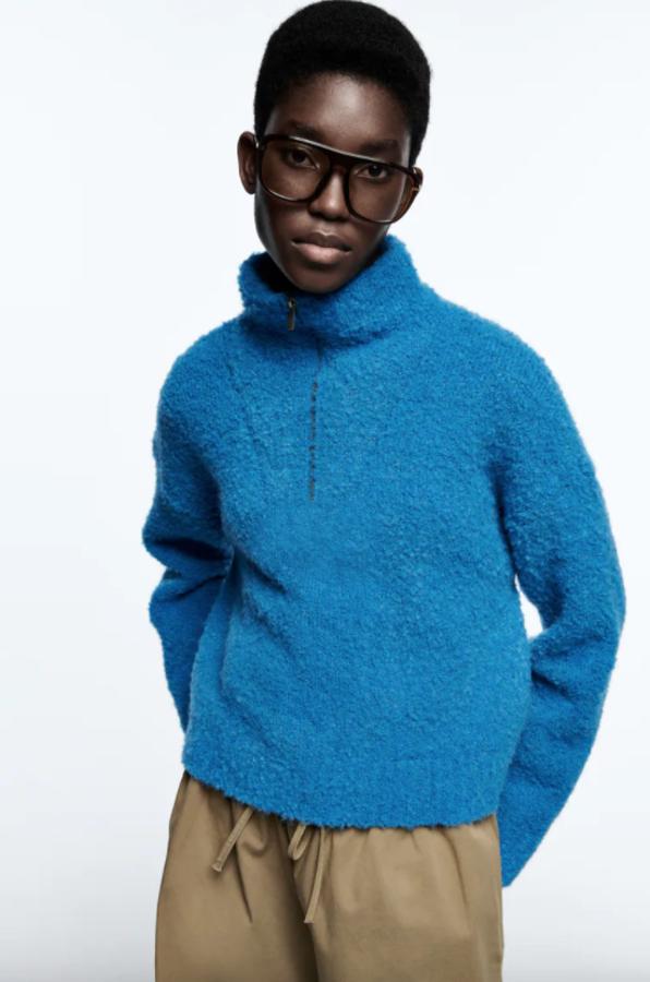 En color azul y efecto pelo, este jersey de cuello subido con cremallera y manga larga es de Zara y cuesta 29,95 euros. 