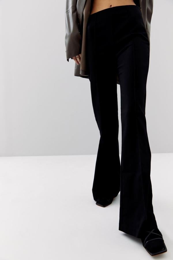 Con bajo ligeramente acampanado y corte recto, estos pantalones de talle alto con cintura elástica son de H&M y vienen con perneras con raya cosida. Podemos comprarlos por 24,99 euros.