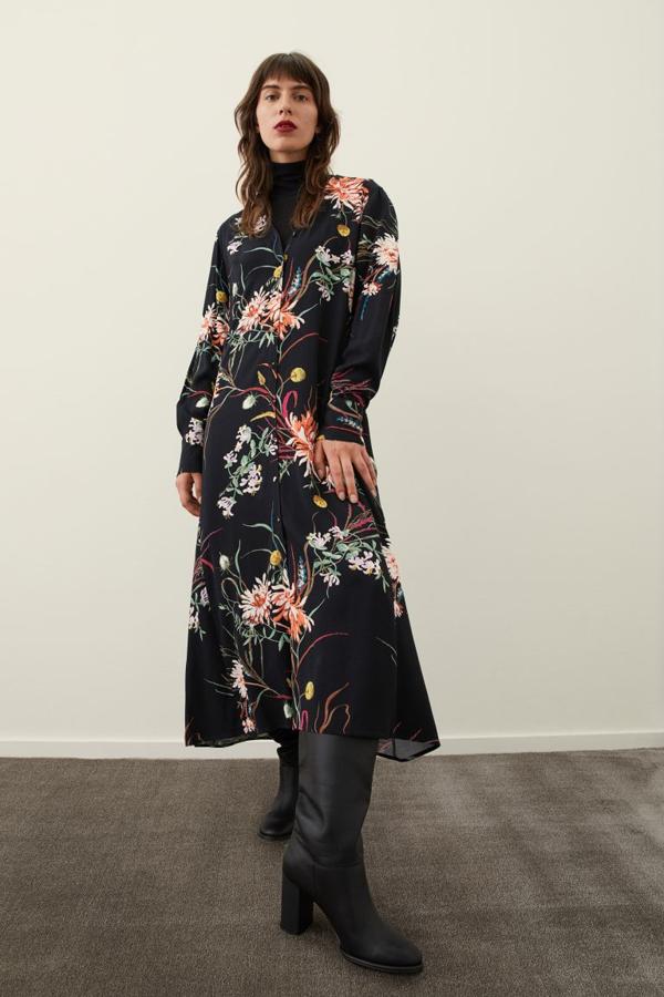 Diseño camisero para este vestido de H&M en color negro con estampado de flores multicolor que está confeccionado en sarga de viscosa y viene con escote de pico, diseño de hombros ligeramente caídos y cinturón de anudar extraíble. Podemos comprarlo por 29,99 euros. 