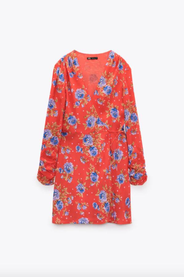En color rojo, con estampado de flores en azul y verde, este vestido con escote de pico y mangas largas con fruncido es de diseño cruzado con lazada y cuesta 29,95 euros. 