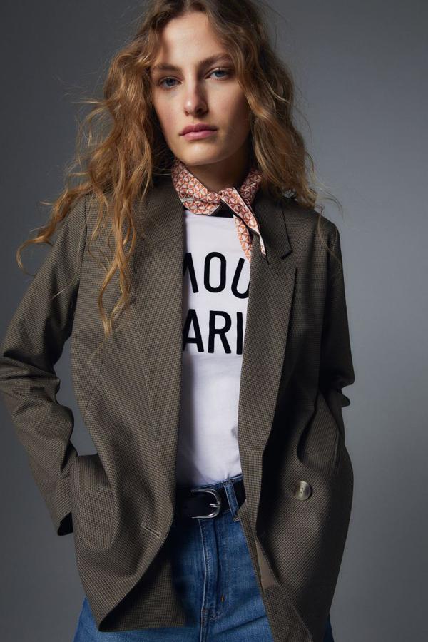 Estampado de pata de gallo mini en tonos marrones para esta blazer de H&M de corte recto, con doble botonadura, solapas de muesca y bolsillos delanteros ribeteados. Tiene un precio de 29,99 euros.