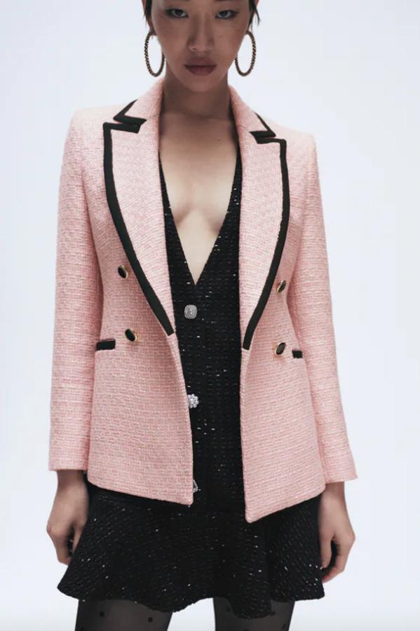 En color rosa, con detalle de vivos combinados a contraste en negro en los bolsillos y el cuello de solapa, esta blazer de Zara de hombros marcados es de cierre frontal cruzado con botones metálicos y tiene un precio de 59,95 euros. 