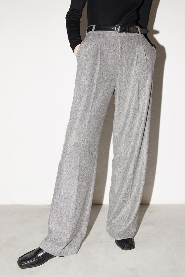 En gris jaspeado, con perneras amplias y rectas y pinzas delanteras, estos pantalones de Sfera con bajo largo cuestan 29,99 euros. 