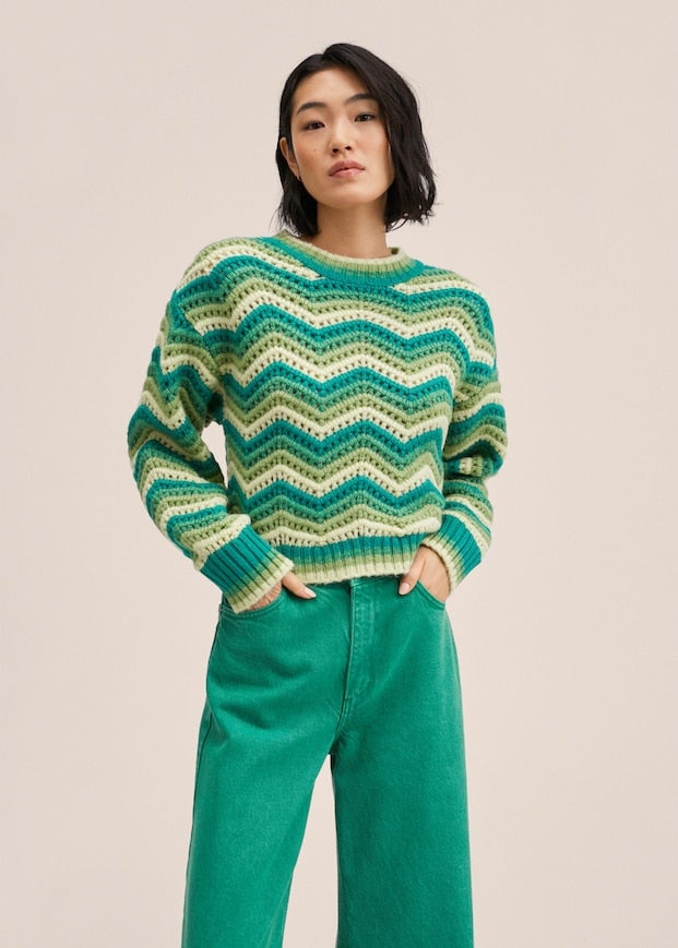 No es estrictamente verde, sino multicolor, pero no nos hemos podido resistir a incluir este bonito jersey de punto de Mango en nuestra selección. Este modelo cropped, con cuello redondo y diseño de ondas en varios tonos de verde, tiene un precio de 39,99 euros. 
