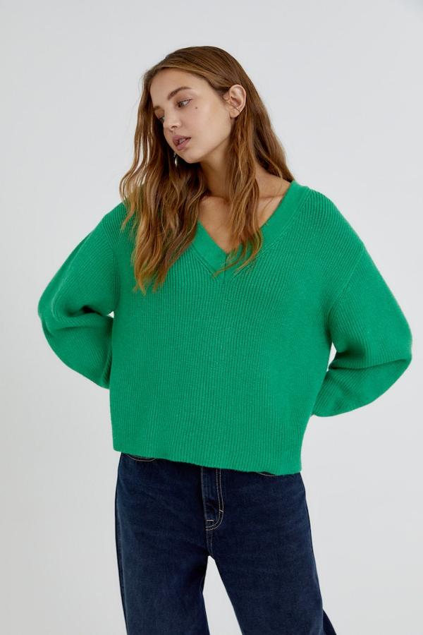 En punto perlado y con escote de pico, este jersey verde de diseño holgado es de Pull&Bear y tiene un precio de 22,99 euros. 