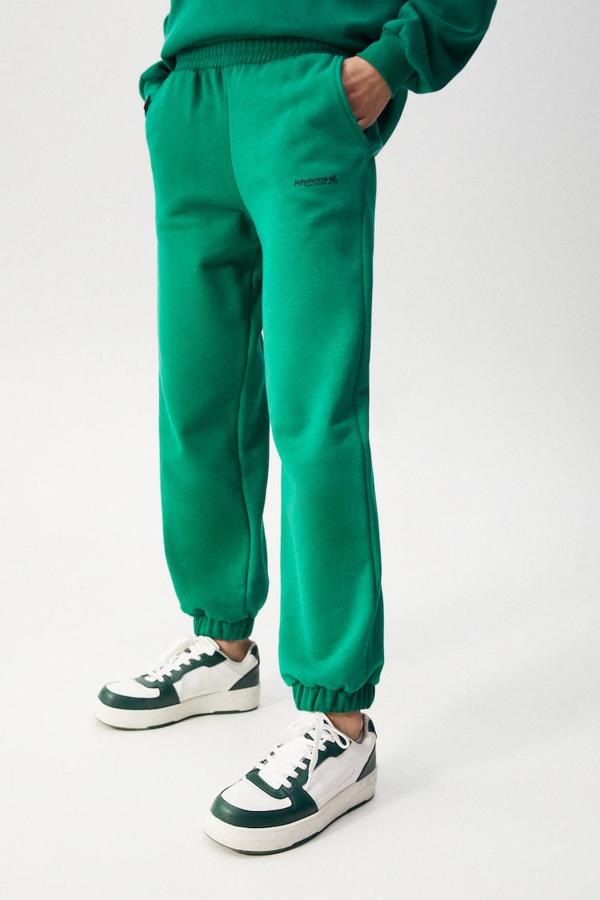 Cintura y bajos elásticos para estos pantalones jogger de Pull&Bear en color verde que tienen texto a contraste en una de las perneras y bolsillos laterales. Podemos comprarlos actualmente por 19,99 euros. 