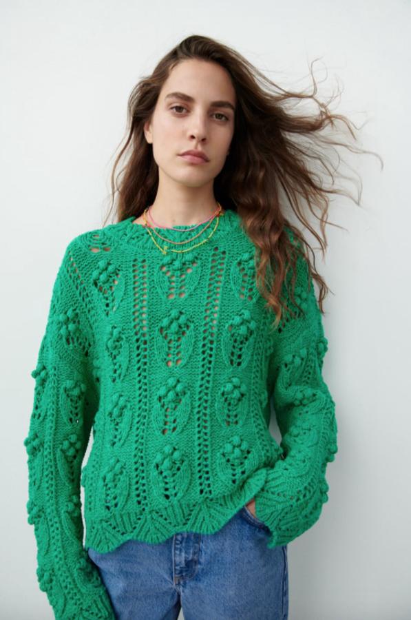 Con cuello redondo y detalle de calados y pompones en el cuerpo, este jersey de punto de Zara en color verde tiene un precio de 29,95 euros. 