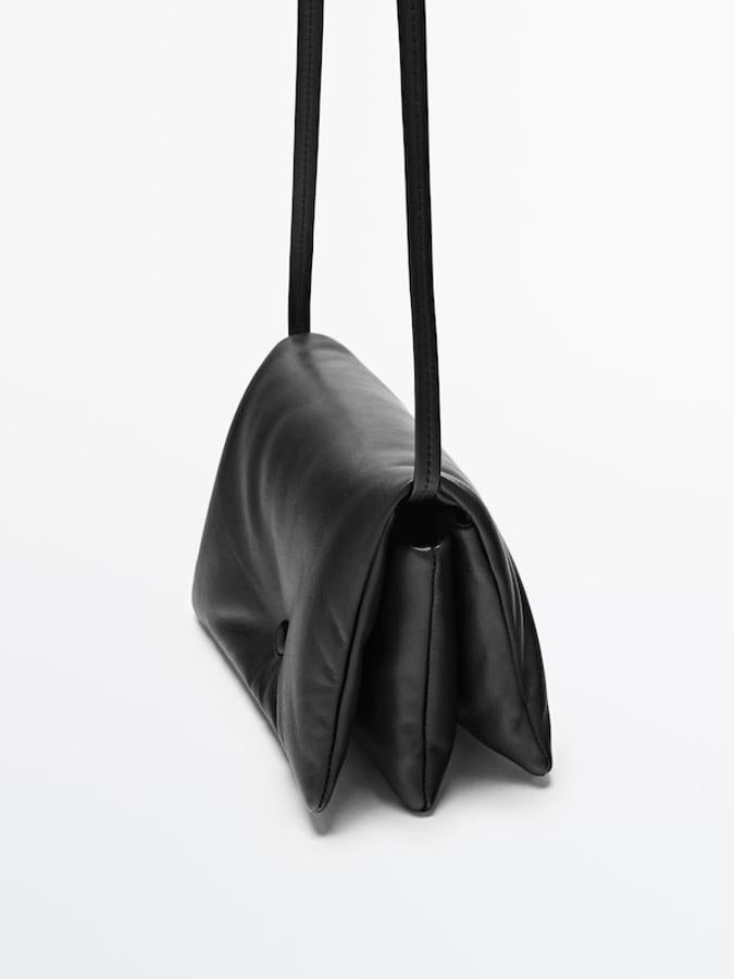 Con dos compartimentos principales y confeccionados en piel ovina, este bolso negro acolchado de Massimo Dutti vienen con correa de hombro ajustable y cierre de solapa imantada con snap oculto. Ahora cuesta 69,95 euros. 