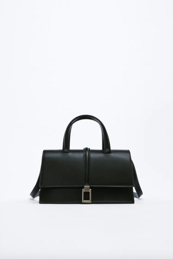 Formato city para este bolso con detalle de hebilla metálica e interior forrado dividido en varios compartimentos que tiene asa de mano y asa función bandolera ajustable y podemos encontrar en Zara por 29,95 euros. 