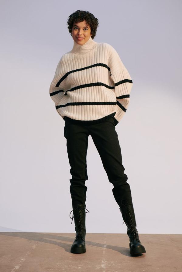 En punto de canalé suave, con cuello alto y hombros marcadamente caídos, este jersey blanco con rayas negras que solo podemos comprar en la web de la firma viene con mangas amplias y cuesta 59,99 euros.