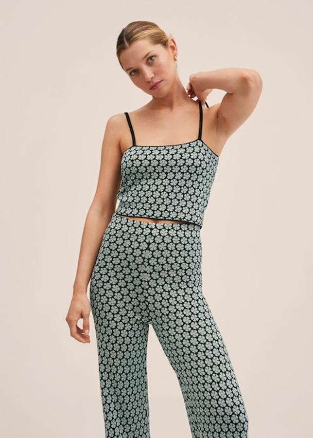 En tejido de punto fino y con estampado retro de flores azules sobre fondo negro, este top crop de diseño y cuello rectos, viene con tirantes finos y cuesta 19,99 euros. 