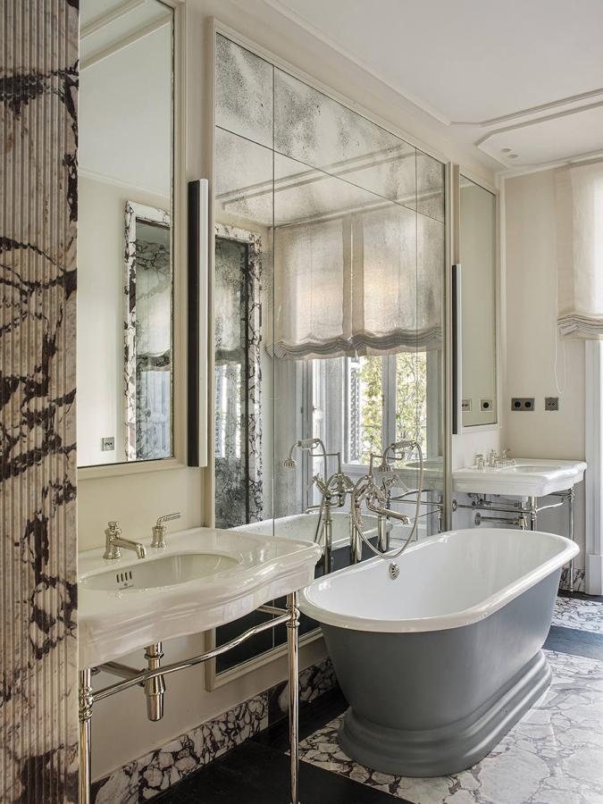 “Nos gusta diseñar distintos formatos de suelo, paredes y techos. Así conseguimos muchas texturas pero sin recargar el ambiente. Arriba, suelo y pared de piedra Viola Calacatta y bañera de Drummonds. El aplique es de Nanometro Studio”.