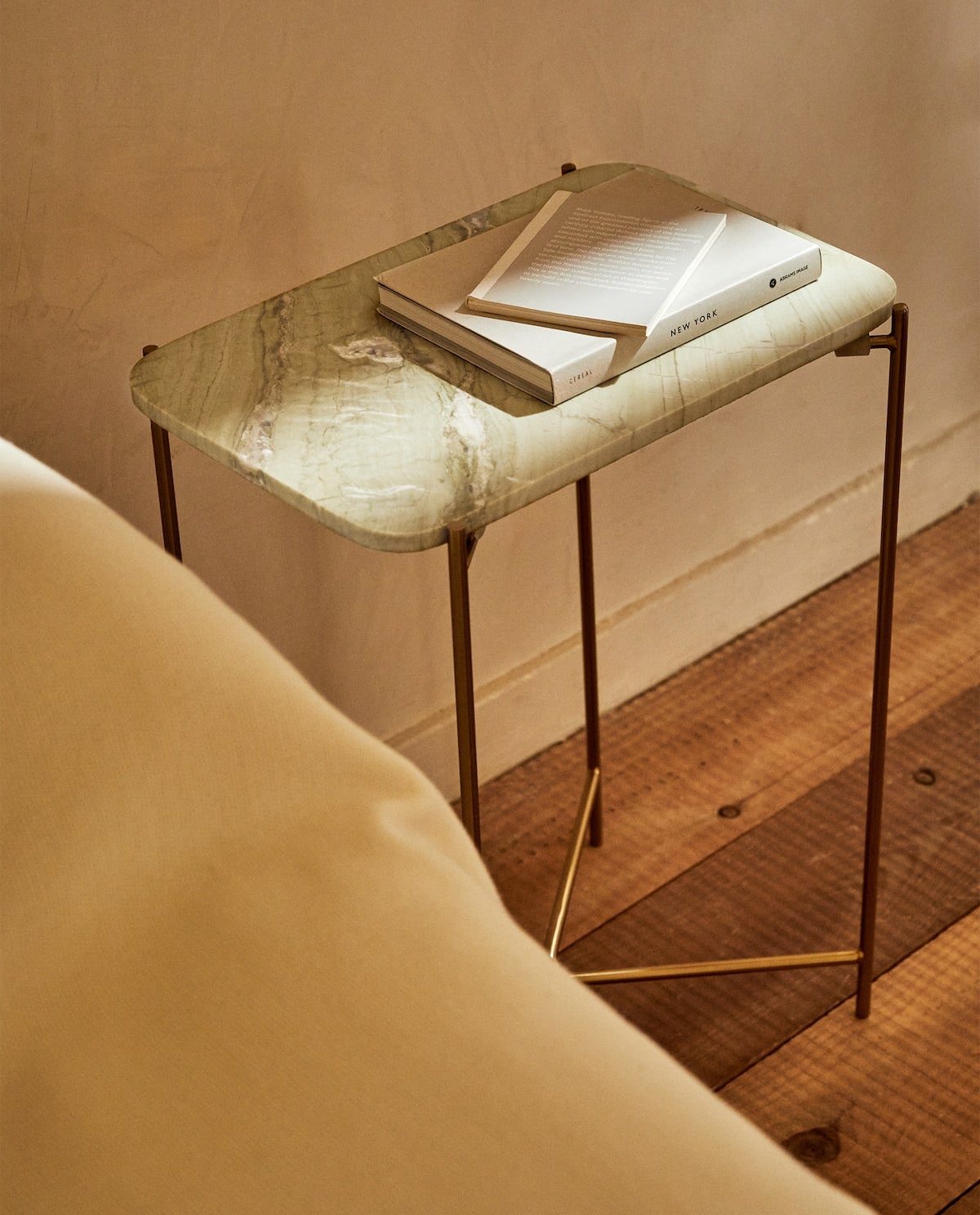 Esta mesilla de mármol con patas doradas es ideal para poner una nota lujosa y muy tendencia a tu dormitorio. Está rebajada a 39.99 euros en Zara Home