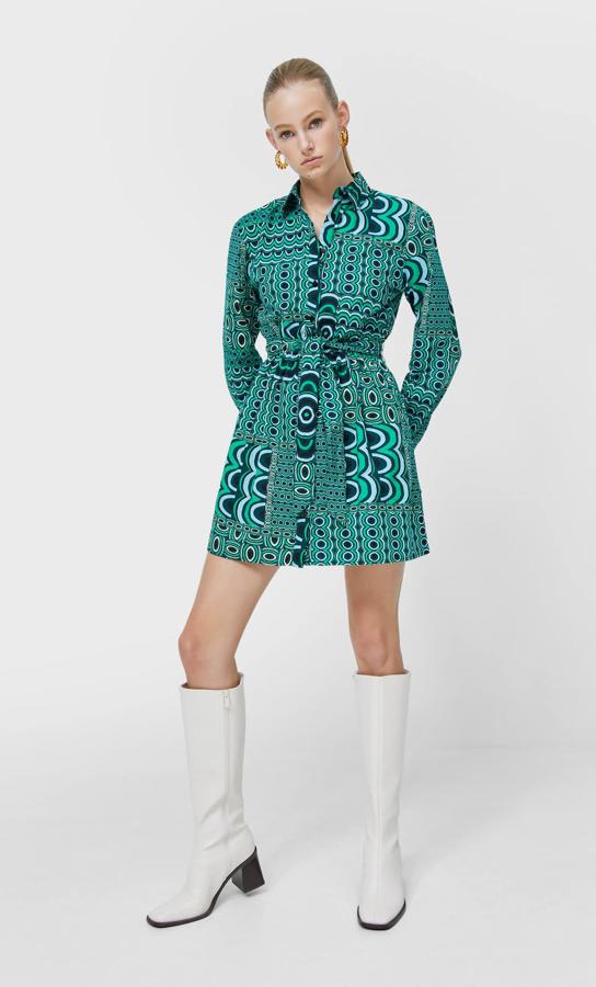 Diseño geométrico en tres formatos diferentes para este vestido camisero corto en tonos verde esmeralda y azul con cuello de solapa y cinturón de lazada a tono que costaba 22,99 euros y ahora podemos comprar por 15,99 euros entre las tallas XS y L. 