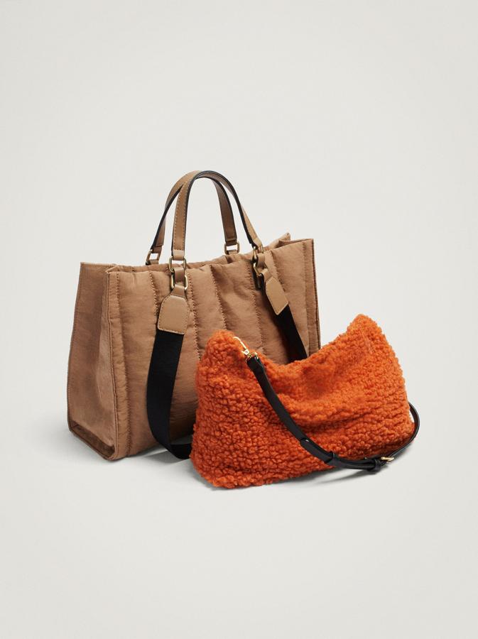 Disponible en camel o en negro, este bolso shopper de nylon con doble asa de mano y doble asa de hombro que podemos encontrar en Parfois viene con bolso interior extraíble de pelo y de contraste de color que tiene cierre de cremallera y asa de bandolera ajustable y extraíble. De 29,99 euros ha pasado a costar 19,99 euros. 