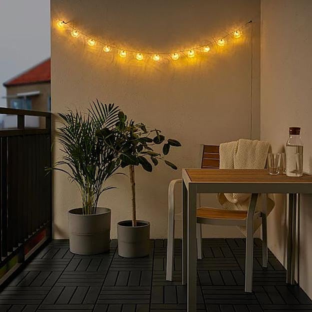 Imagen principal - La guirnalda de luces está rebajada a 6 euros en el outlet de IKEA, la lámpara de techo de inspiración industrial, 9 euros; y el farolillo decorativo, 6 euros.