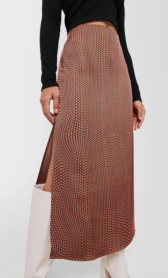 Estampado de círculos en color café sobre fondo marrón para esta falda de satén de Stradivarius de tiro alto con abertura lateral en el bajo que de 19,99 euros ha pasado a costar 5,99 euros y podemos encontrar entre las tallas 34 y 42. 