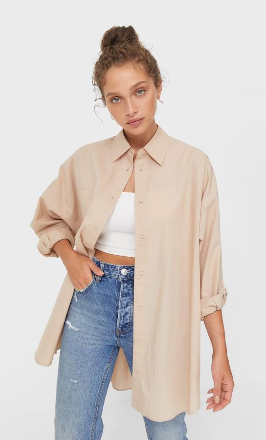 Con cuello de solapa y mangas largas, esta camisa oversize en tejido de popelín es de Stradivarius y podemos encontrarla en azul claro, piedra o blanco. Con bajo asimétrico con aberturas laterales ligeramente redondeado, tiene un precio de 19,99 euros y podemos encontrarla entre las tallas XS y L. 