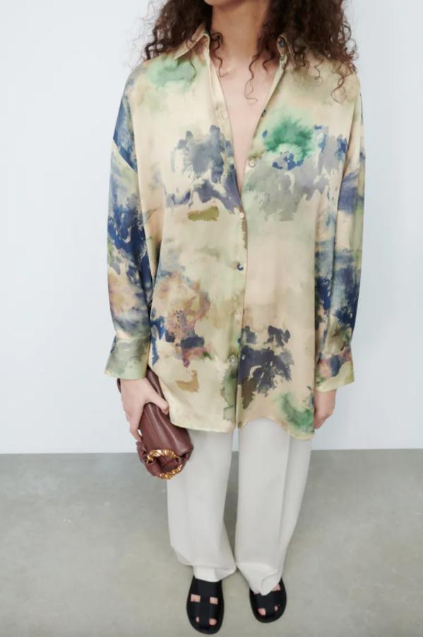 En color vainilla, con estampado degradado en tonos azules y verdes, esta camisa fluida de Zara con cuello de solapa y mangas largas en tejido satinado viene con cierre frontal de botones a tono y cuesta 22,95 euros. Está disponible entre las tallas XS y XL. 