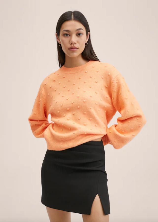 En punto con textura a lo largo de toda la prenda y con cuello perkins, este jersey de color mandarina con terminaciones de canalé y de diseño recto cuesta 29,99 euros. 