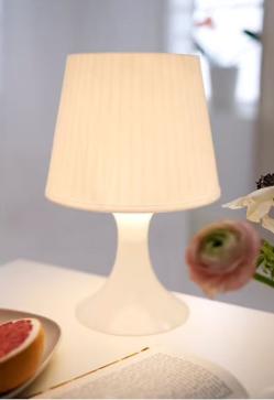Imagen secundaria 2 - La lámpara de techo de papel redonda cuesta 6 euros en IKEA; la mesilla de madera con un cajón cuesta 30 euros y la lámpara de mesilla blanca cuesta 6 euros.
