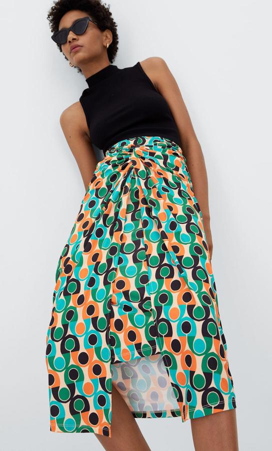 Estampado geométrico de diseño retro en tonos naranjas, verdes y azules para esta falda midi de punto de Stradivarius con tiro alto y detalle anudado en la cintura que cuesta 19,99 euros y está disponible en las tallas S, M y L. 