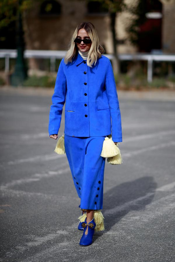 Una fórmula que hemos visto en más ocasiones en el street style como esta, donde adornaban este dos piezas en azul con borlas de flecos en amarillo.