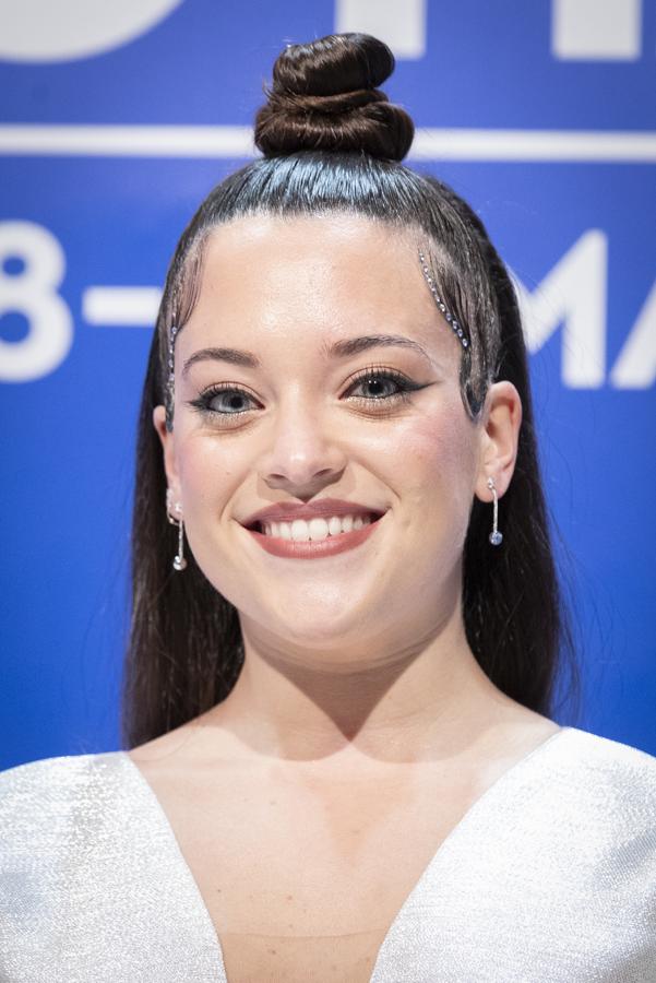 Y si no quieres perder la oportunidad de lucir melenaza, puedes escoger el moño alto, pero semirrecogido como ha hecho la cantante Noelia Franco.