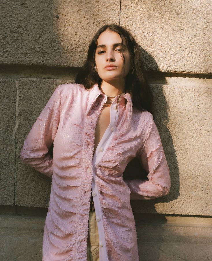 Vestido camisero de lentejuelas y pantalón vaquero, ambos de Ganni. Cinturón de Celine; pendientes de Swarovski; y collares de Mais x Frida y Pearl Octopuss.y.