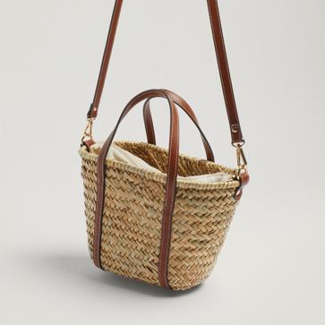 Imagen secundaria 1 - Los diseños confeccionados en tejidos naturales, como la rafia, el yute, la palma, son un auténtico básico cuando suben las temperaturas. Bolso de rafia estilo cesta con asas efecto piel de Parfois (27,99 euros)