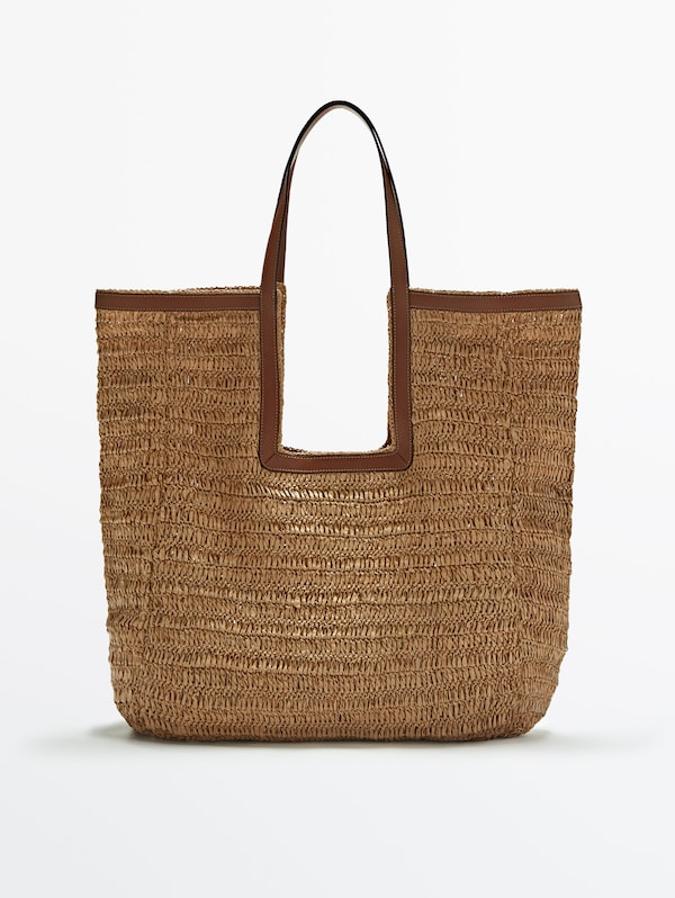 Con un original diseño y un único compartimento principal, este bolso shopper en rafia y piel de Massimo Dutti está disponible en tres colores, marrón, negro y beige y tiene un precio de 129 euros. 