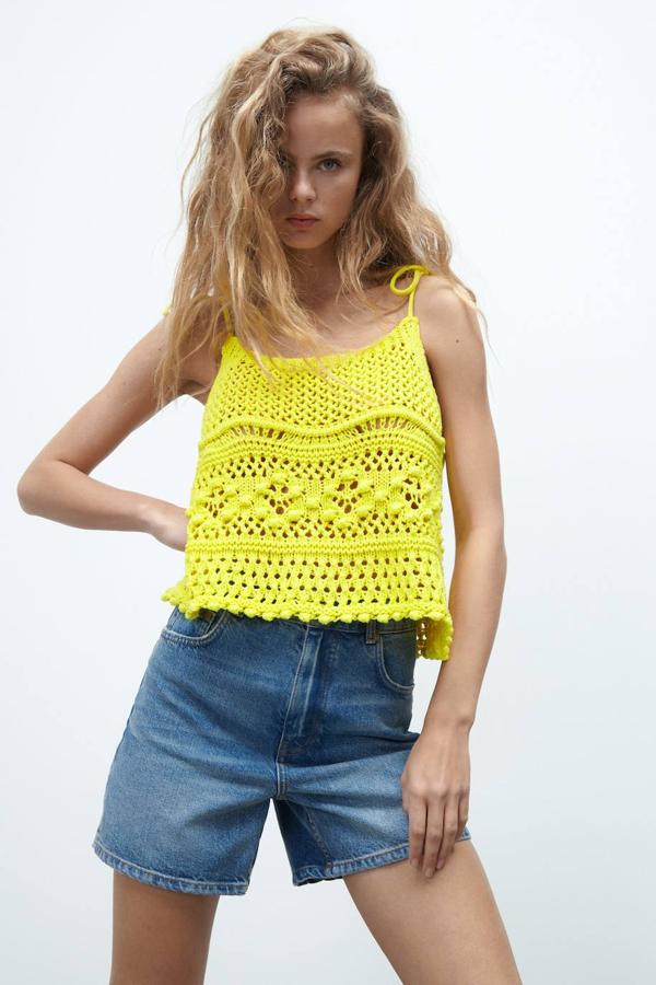 Top de punto ligero y calado con detalles en relieve, escote redondo y tirantes finos con lazos, disponible 2 colores, amarillo o negro, y en las tallas S, M y L. Su precio es de 19,95 euros.